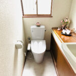 福岡県大野城市でトイレ交換した施工後の画像、LIXILのブルグレーの便器とモルタル調の床がおしゃれで落ち着いた空間を演出してくれています。