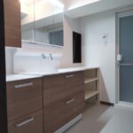 福岡市中央区で洗面所のリフォームをした施工後の画像。TOTOのオクターブlightに交換しました。洗面台の左にはキャビネットを、右には造作の収納棚を設置しました。