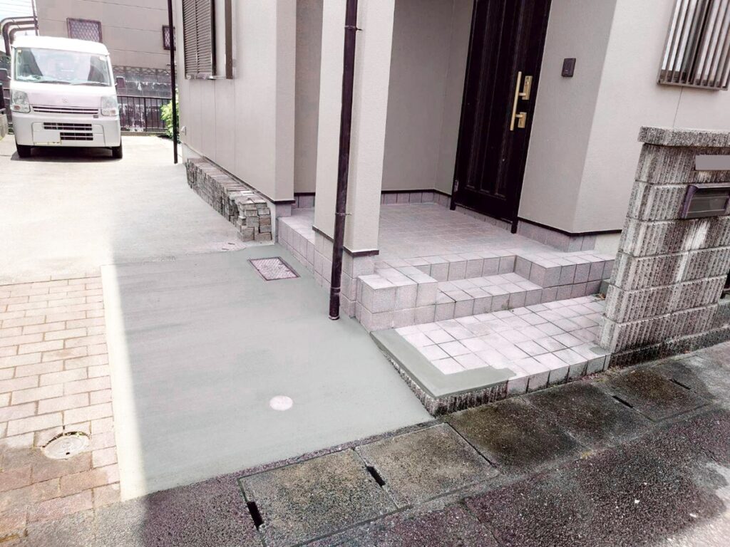 福岡市で水漏工事でインターロッキングをはがして、コンクリートで補修して、出入りしにくかった塀の一部を撤去した施工後の画像。