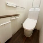 福岡市南区でトイレ交換したリフォーム後の画像。新しいトイレはLIXILのアメージュ。床とトイレのカウンターはウォルナット調の仕様。シンプルイズザストなトイレです。