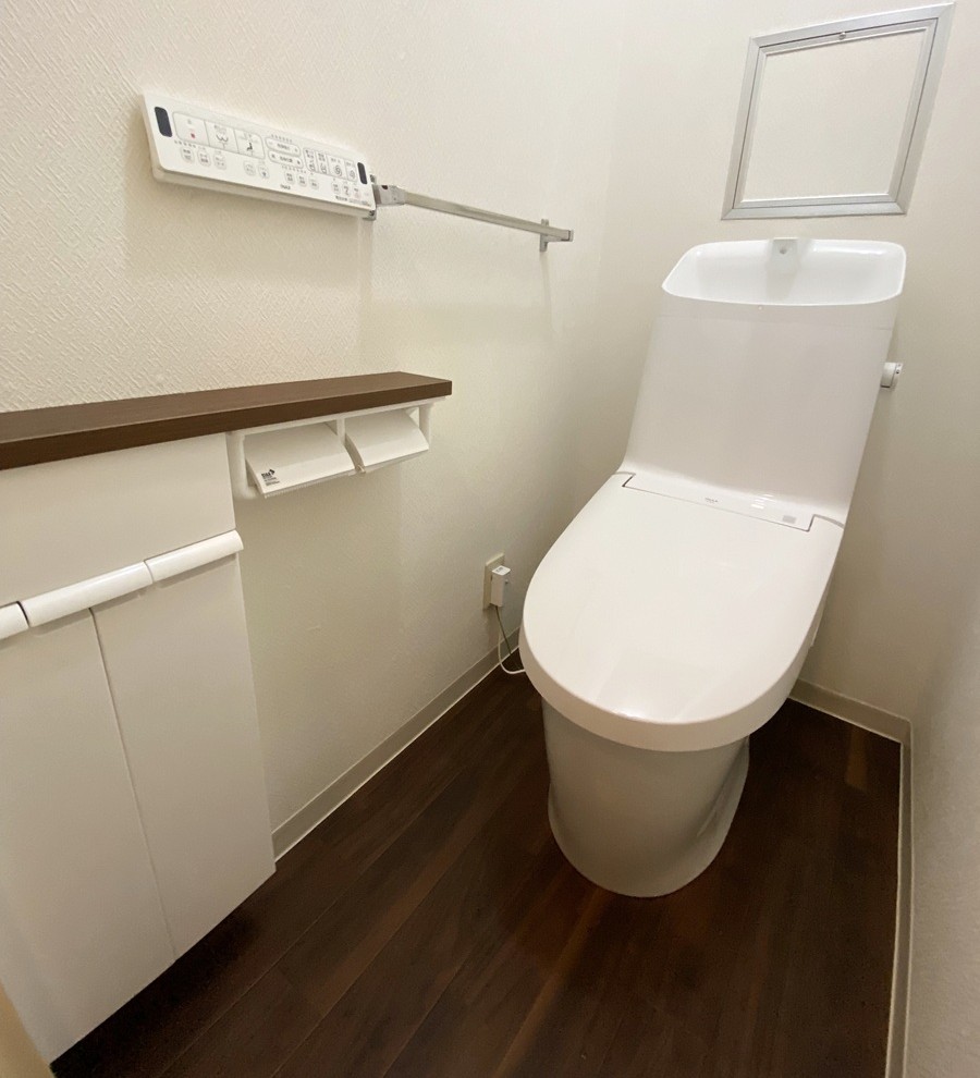 福岡市南区でトイレ交換したリフォーム後の画像。新しいトイレはLIXILのアメージュ。床とトイレのカウンターはウォルナット調の仕様。シンプルイズザストなトイレです。