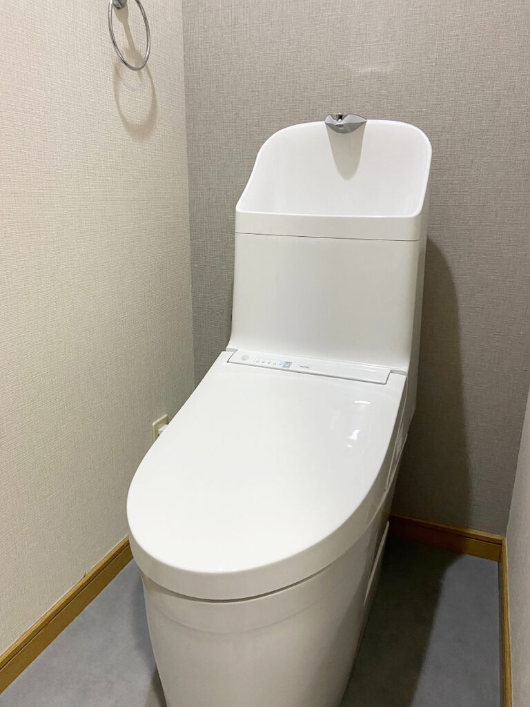福岡市南区でTOTOのGG800にトイレを交換した施工後の画像。グレーのアクセントクロスとグレーのフロアとも相性がよく、清潔感のあるトイレになりました。