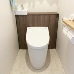 福岡市城南区でトイレ交換工事をした施工後の画像。LIXILのＪフィッというキャブネット付きトイレに交換しました。色はウォルナットです。