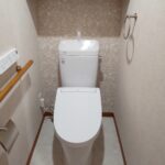 福岡市南区でトイレを交換したリフォーム後の画像。LIXILのアメージュリトイレ。正面入ってすぐの壁にはアクセントクロスを貼って華やかな印象になっています。