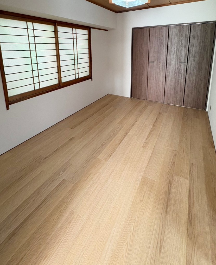 福岡市南区で和室を洋室にリフォームした施工後の画像です。畳を撤去してフロアタイルを貼りました。押入れもウォルナット調のクローゼットに交換したので、洋服を収納できるようになりました。